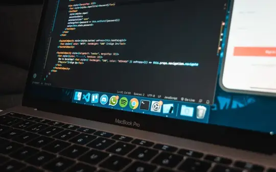 A laptop showing site code at a workspace